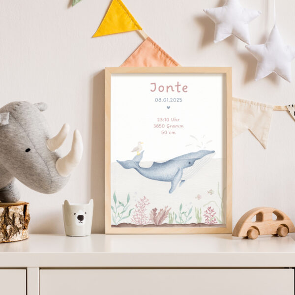 Geburtsposter mit Wal-Motiv, das in einem Kinderzimmer auf einer Kommode steht.